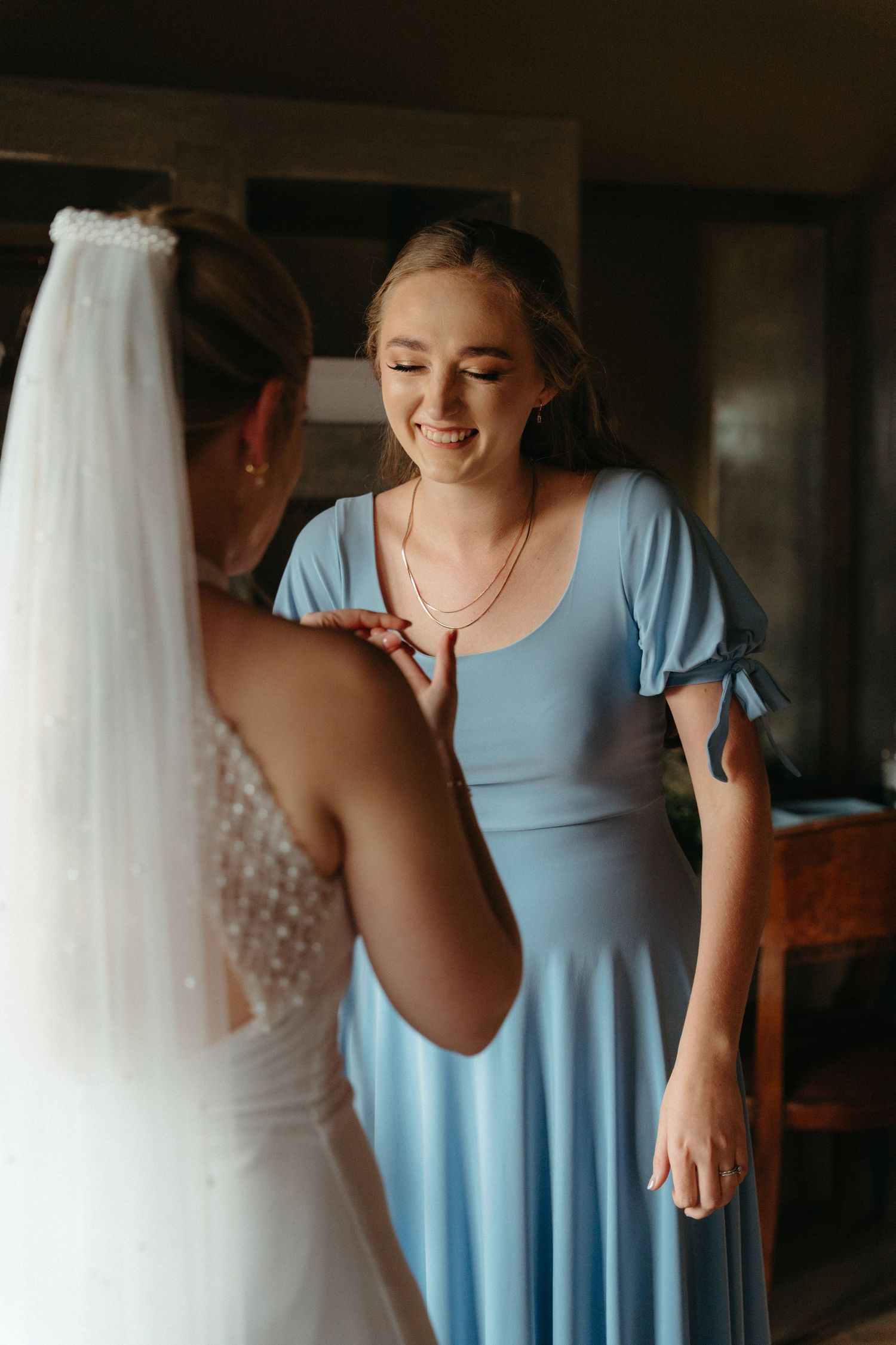 Wedding preparations showing light blue bridesmaid dress and white wedding gown hanging.