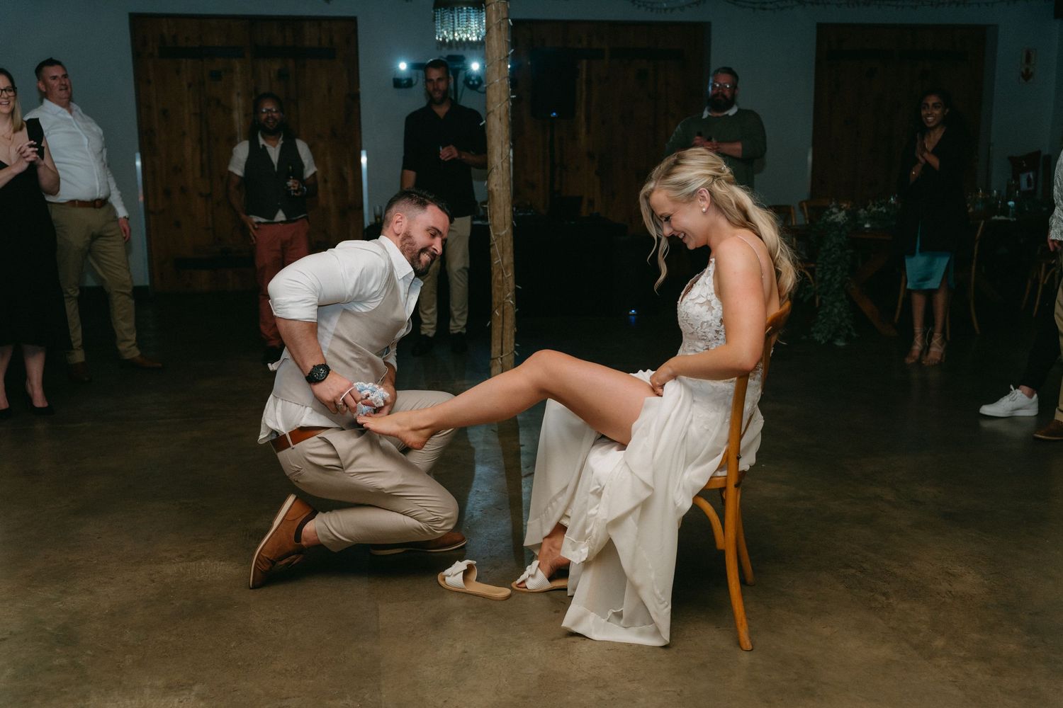 Wedding reception guests participate in a fun party game with chairs.