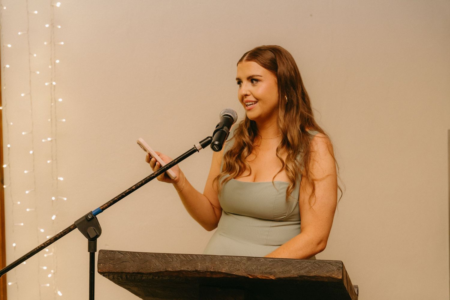 A person speaks into a microphone during a wedding reception.