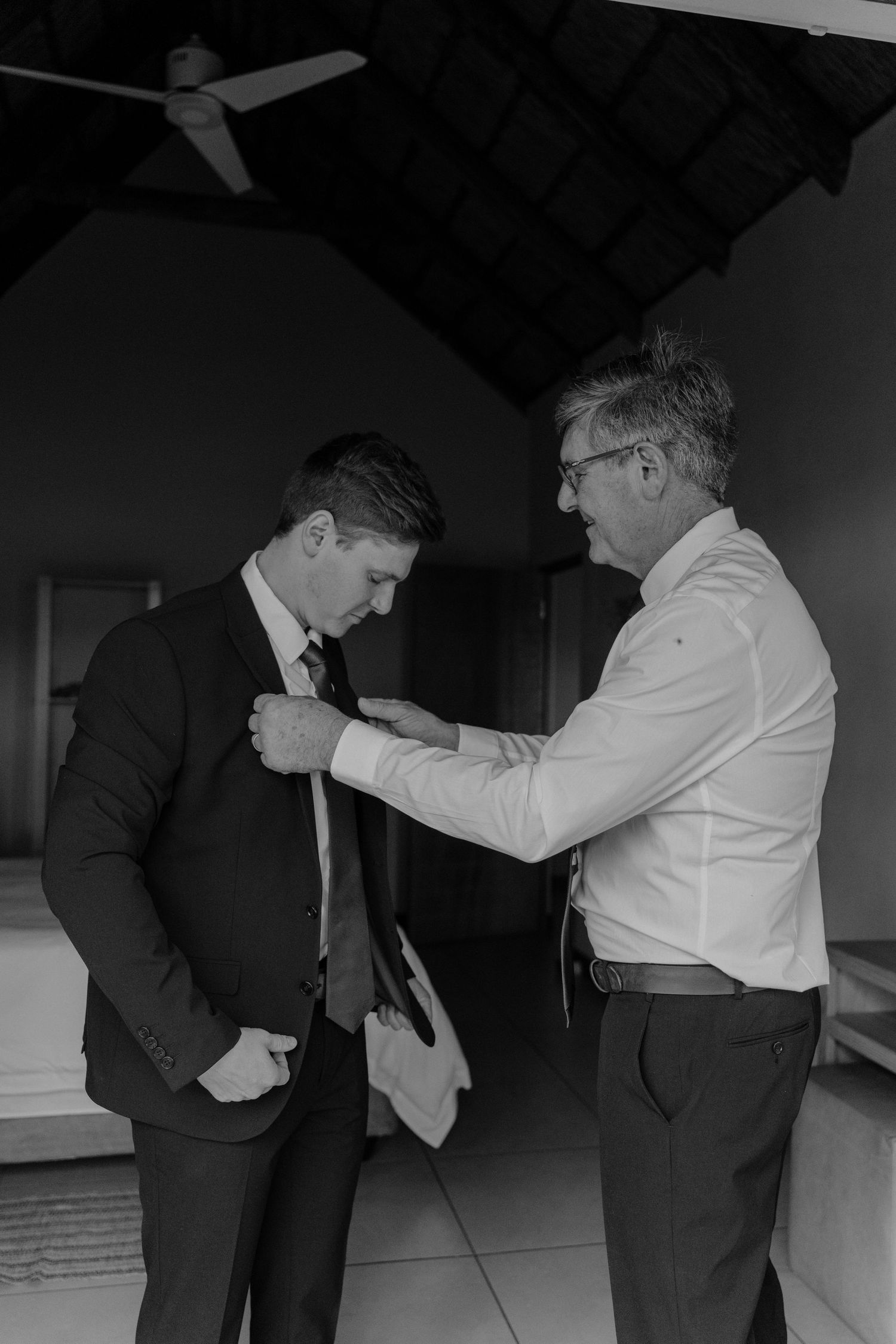 Black and white sequence showing two people helping adjust formal attire.