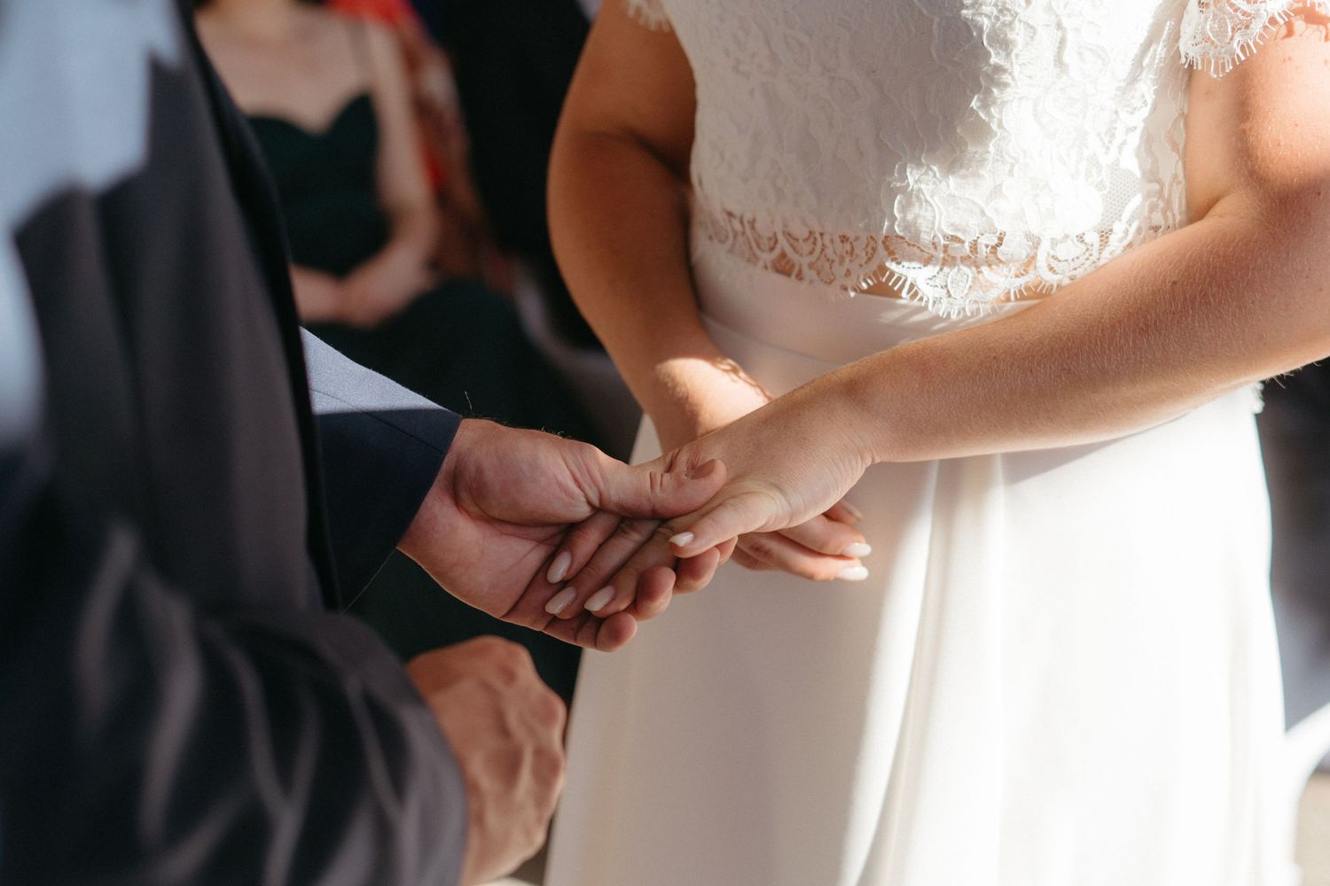 Close-up of hands during wedding ring exchange ceremony.