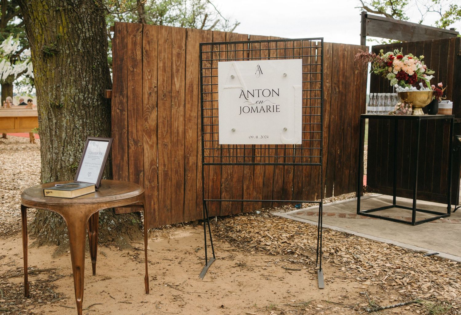 Rustic wooden wedding signage and decor setup with floral arrangements.