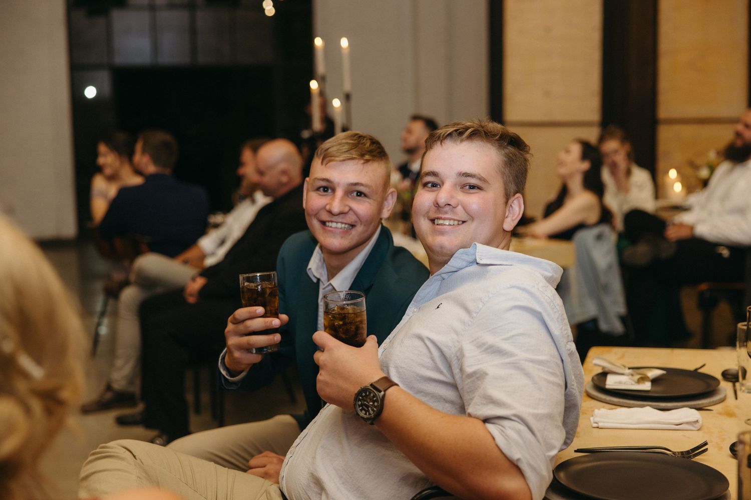 Wedding reception guests enjoying drinks and conversation at elegant indoor venue.