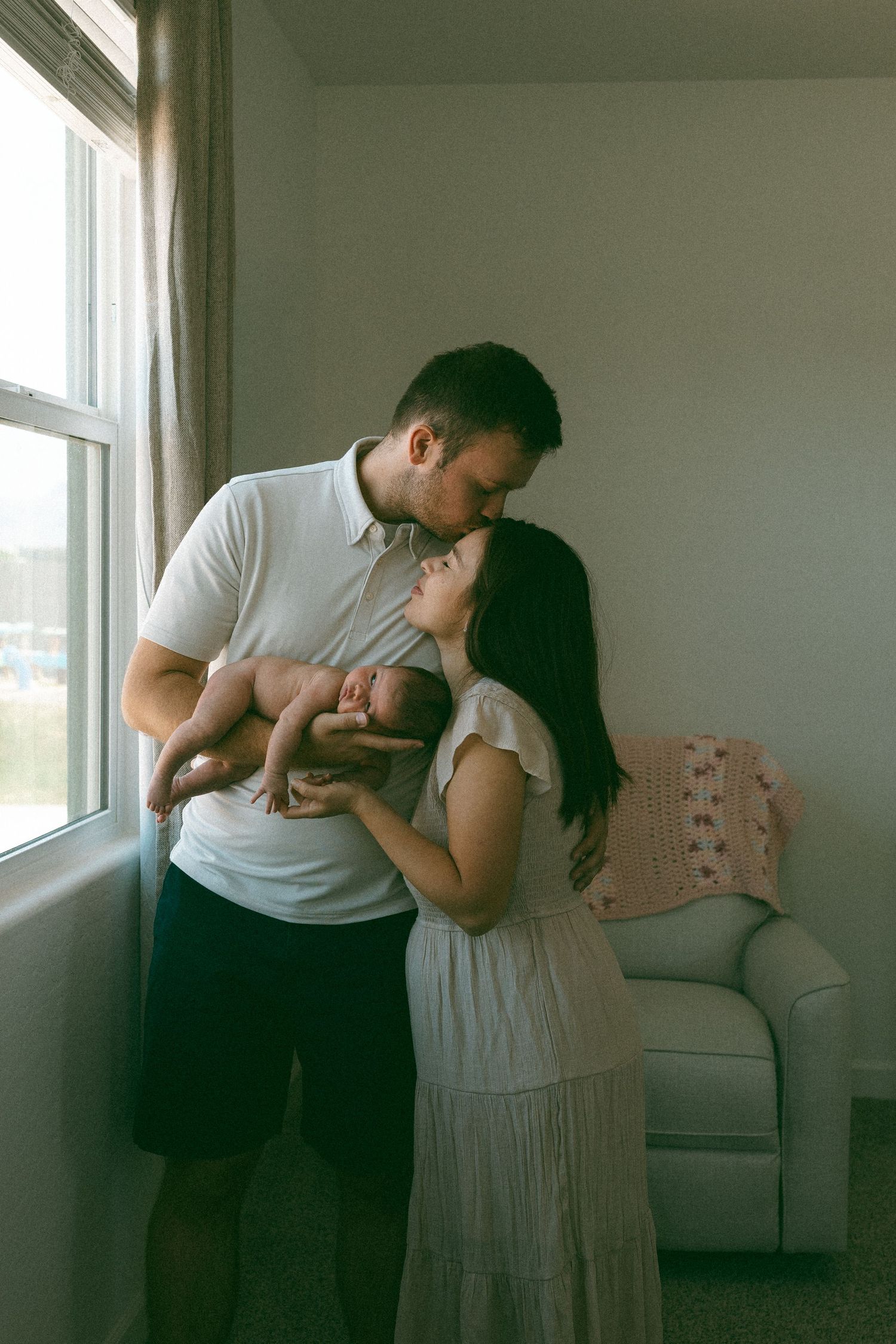 Father and mother embracing with their newborn baby during a lifestyle newborn session