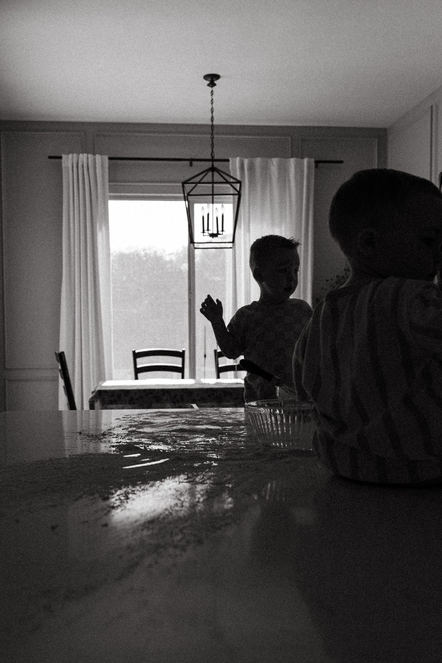 Backlit lifestyle family session with boys playing in kitchen