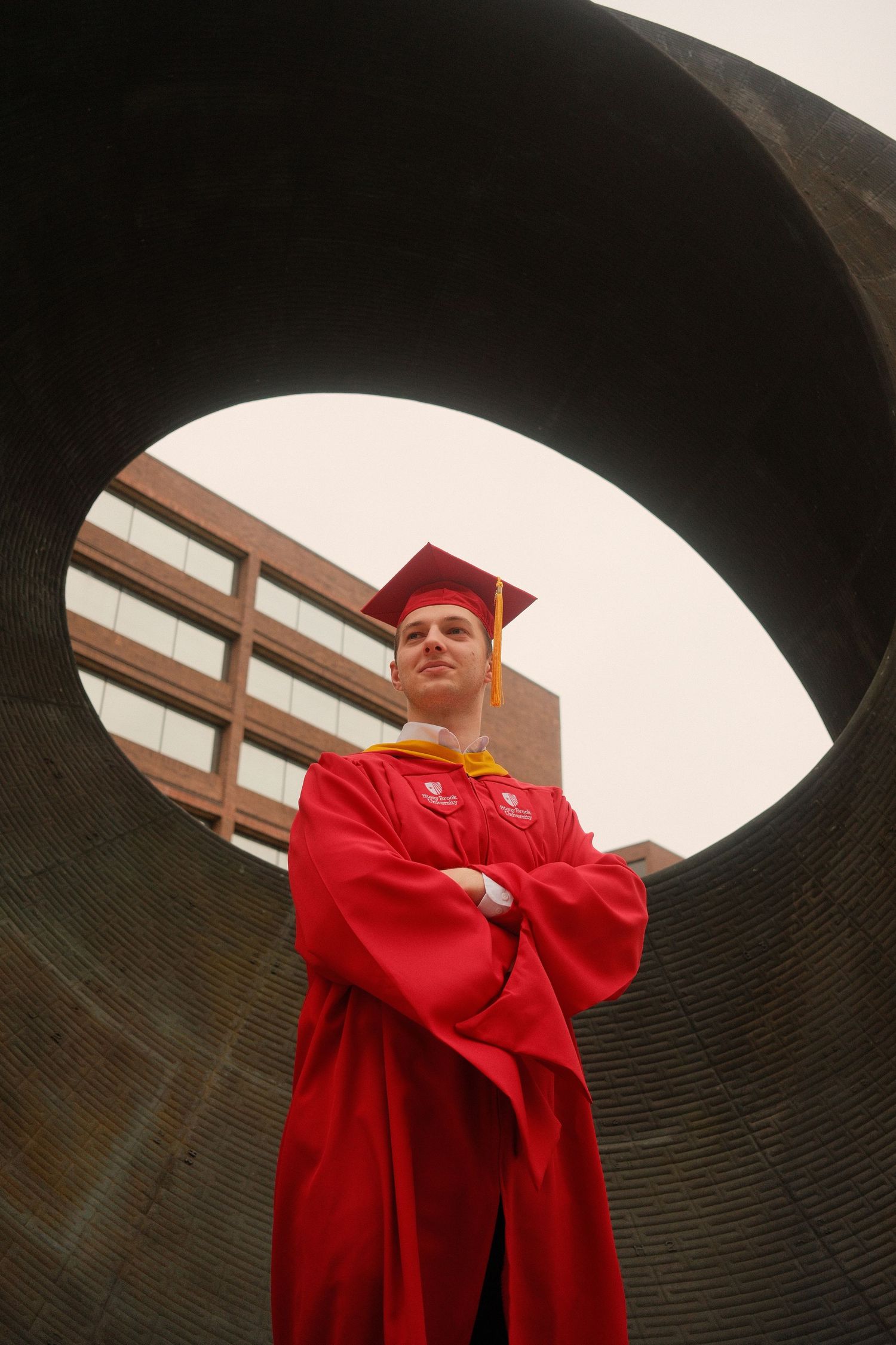 Portrait of graduate in cap and gown captured with natural light.
