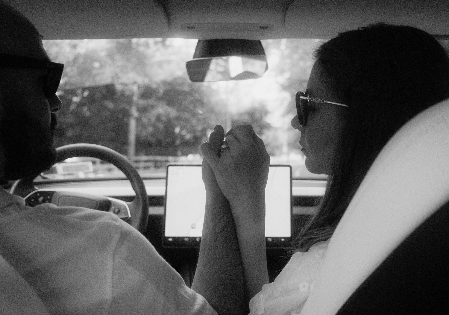 Romantic detail shot of hands and rings during an engagement session in a car.