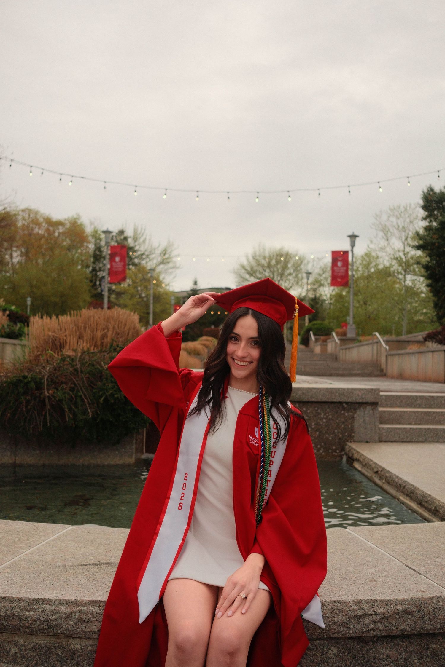 Graduate sitting outdoors during a vibrant graduation portrait session.