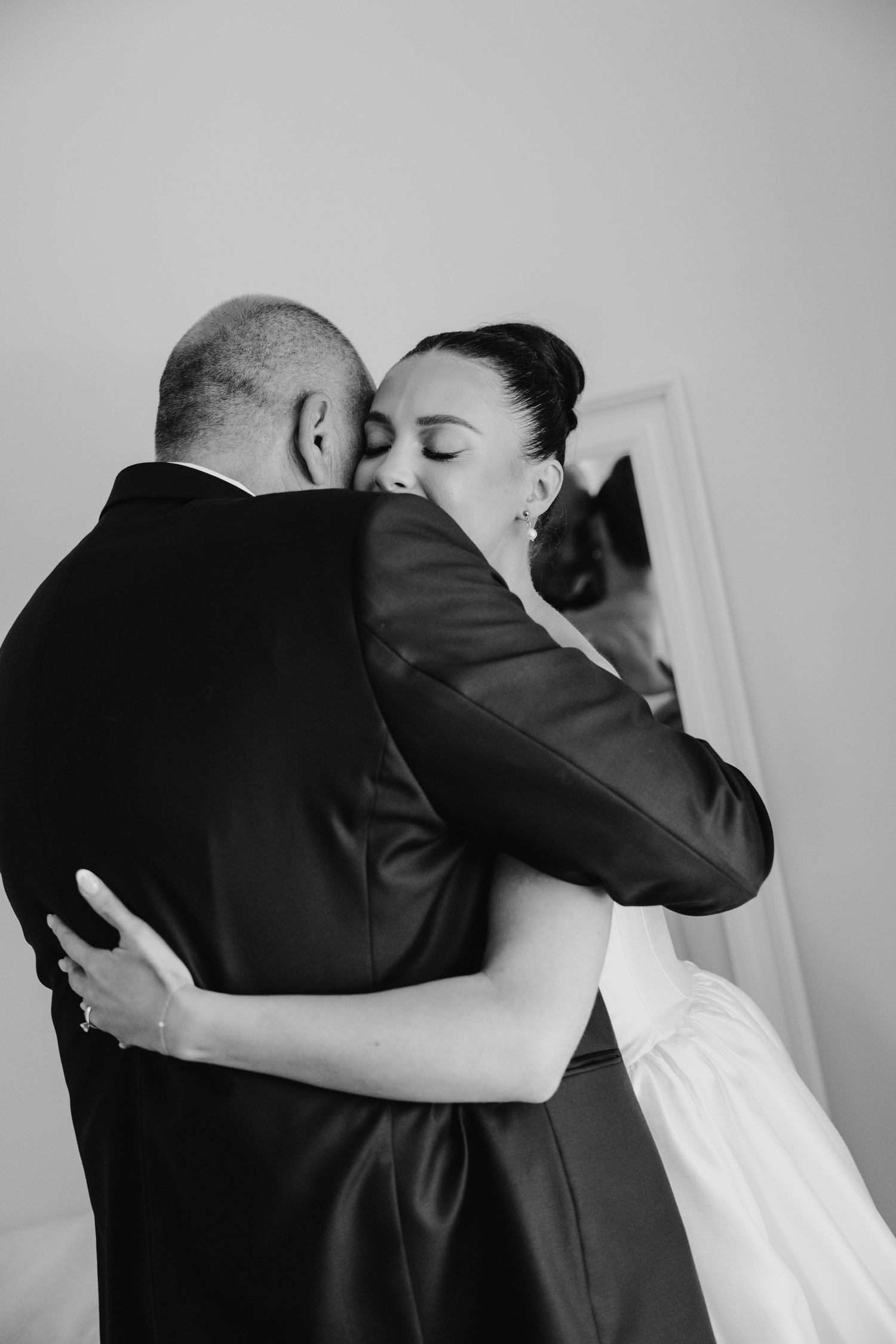 Black and white photo of bride and groom sharing a tender embrace on their wedding day.