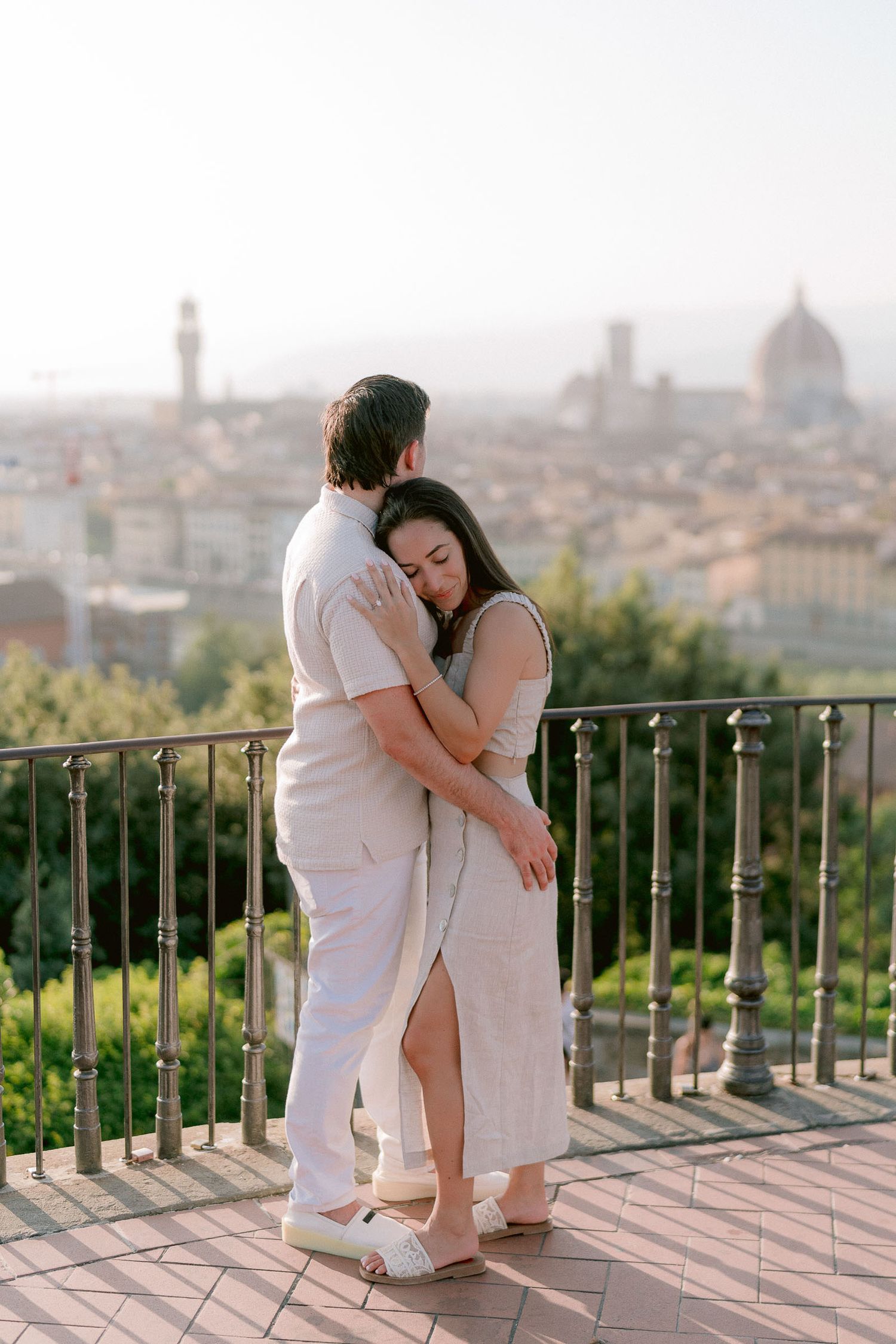 Romantic moment overlooking Florence cityscape from scenic viewpoint at sunset.