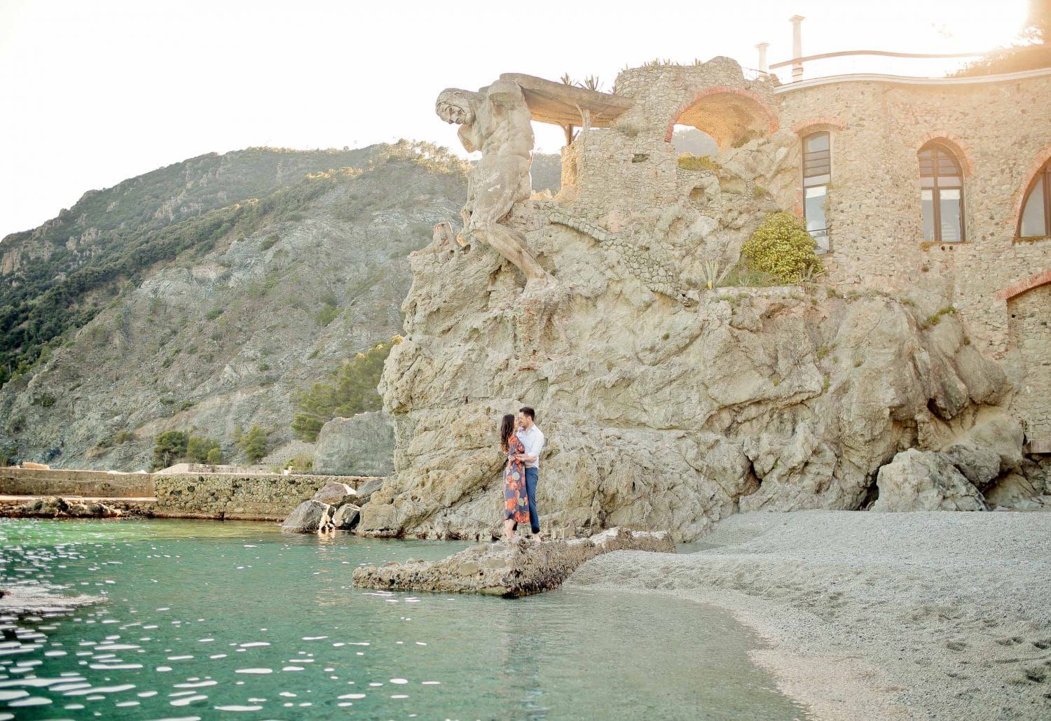 Scenic coastal photoshoot along rocky Mediterranean cliffs at sunset.
