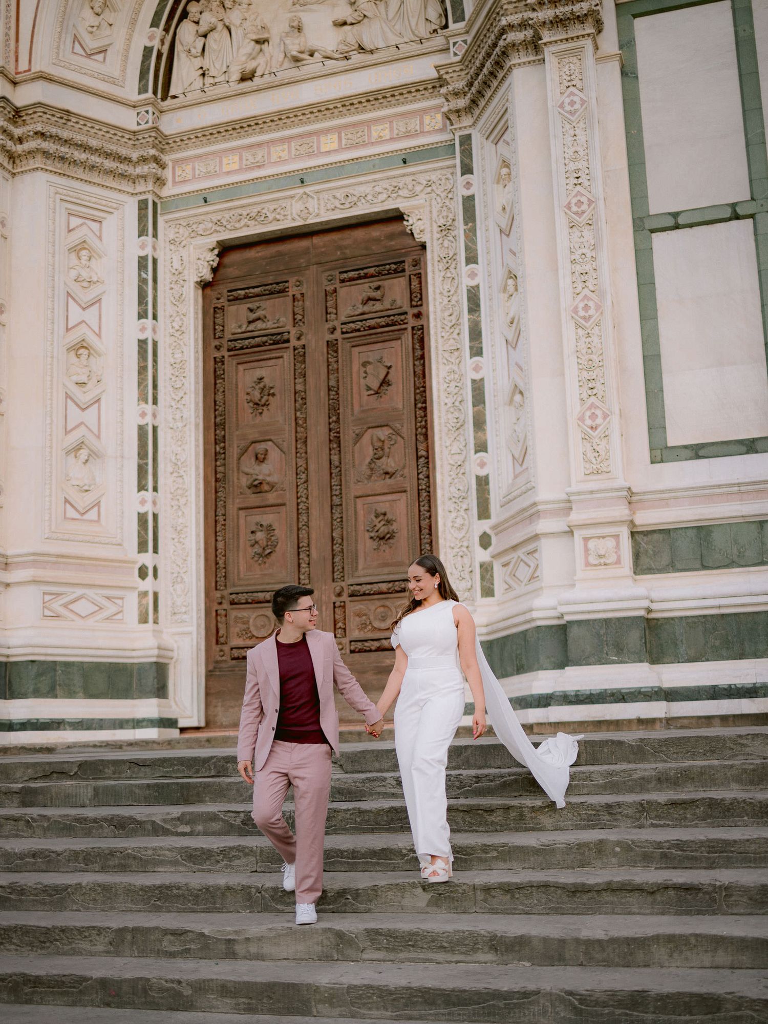 Romantic couple posing on the historic steps of Florence Cathedral in Italy.