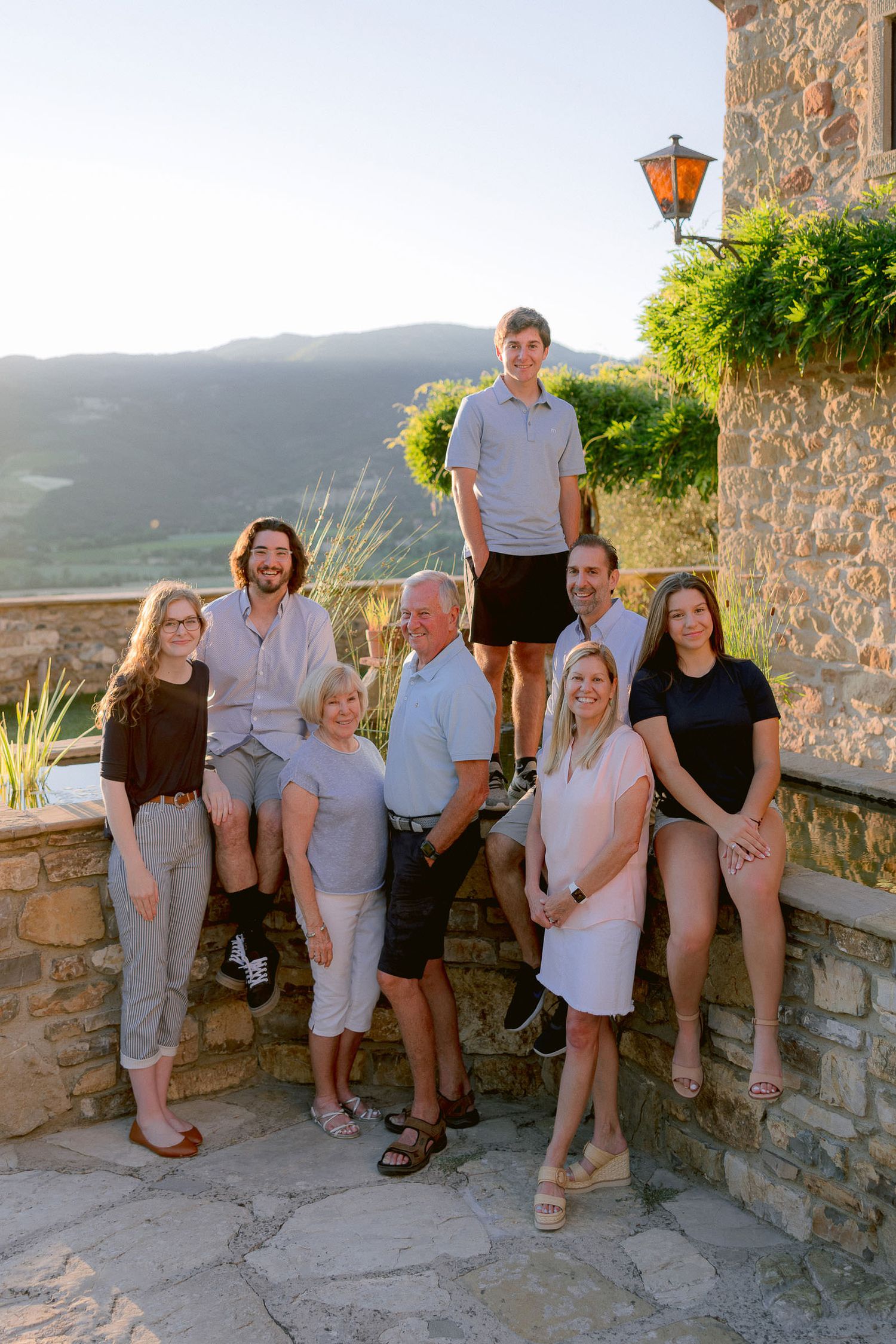 A family group poses together on a stone terrace overlooking a mountain landscape.
