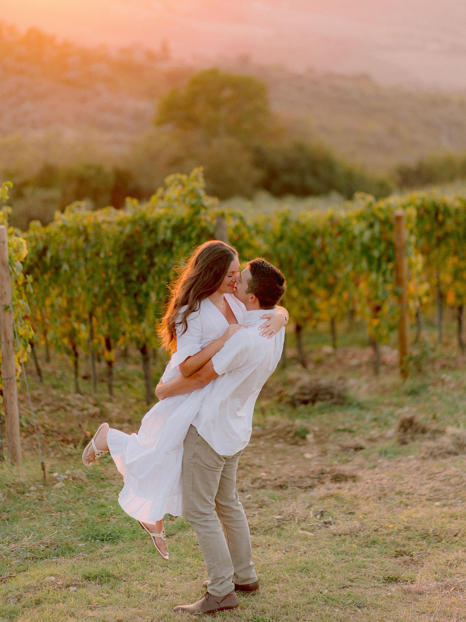 Romantic moment in a hilltop vineyard during golden sunset.