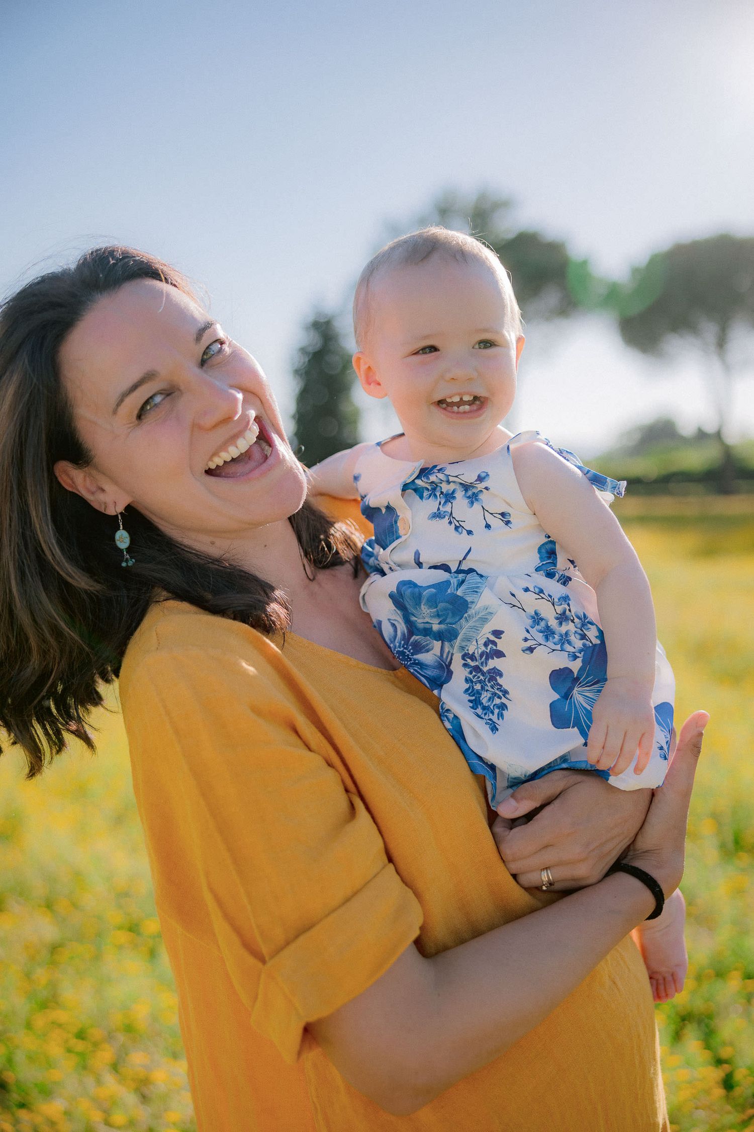 A joyful moment captured outdoors in golden sunlight wearing yellow and blue floral clothing.