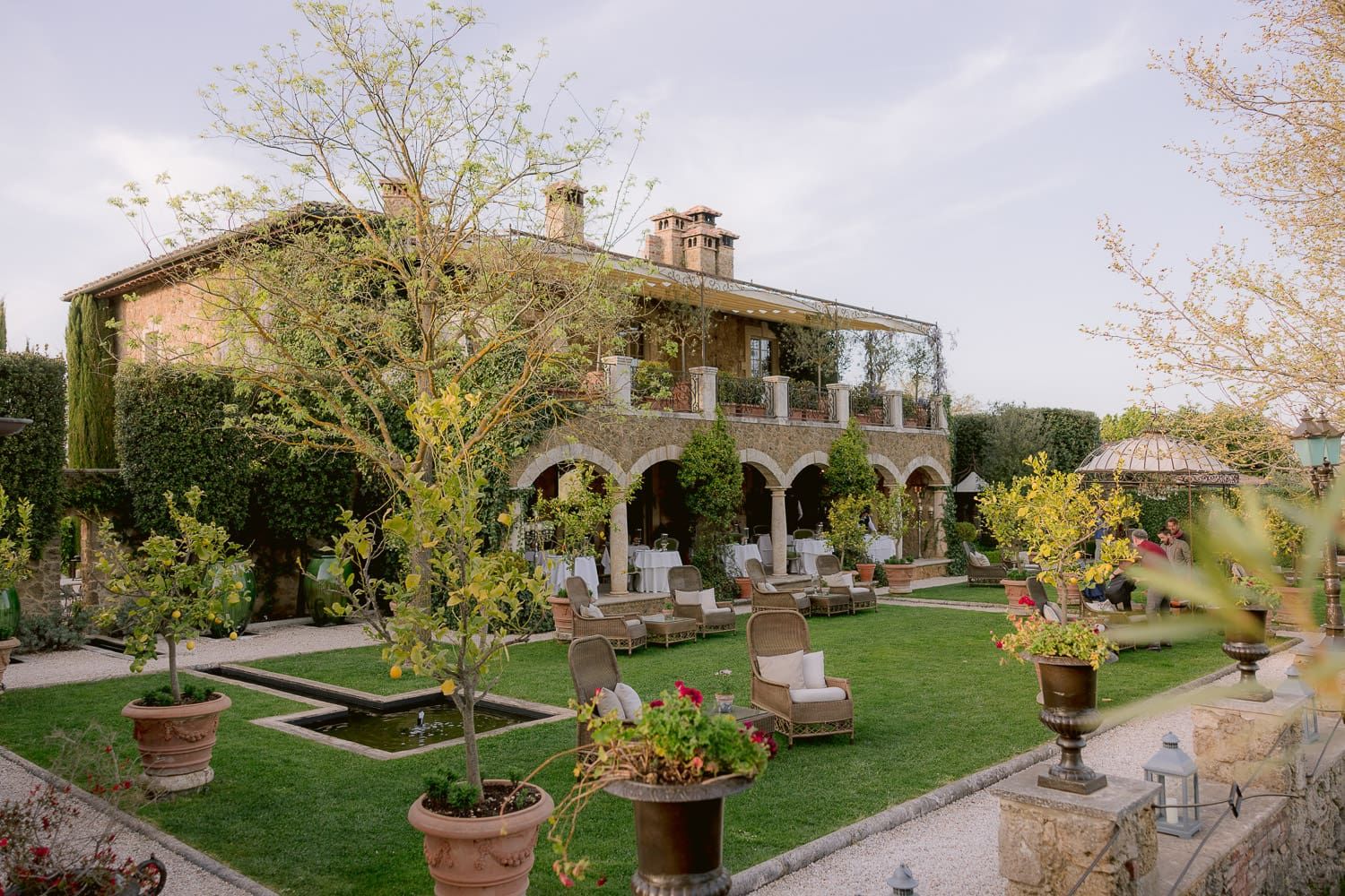 Panoramic view of an Italian villa garden with stone pathways and manicured landscaping.