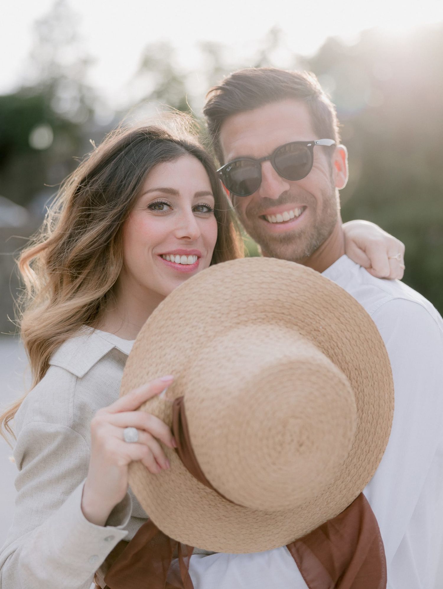 Romantic portrait with a straw hat against sunset lighting.