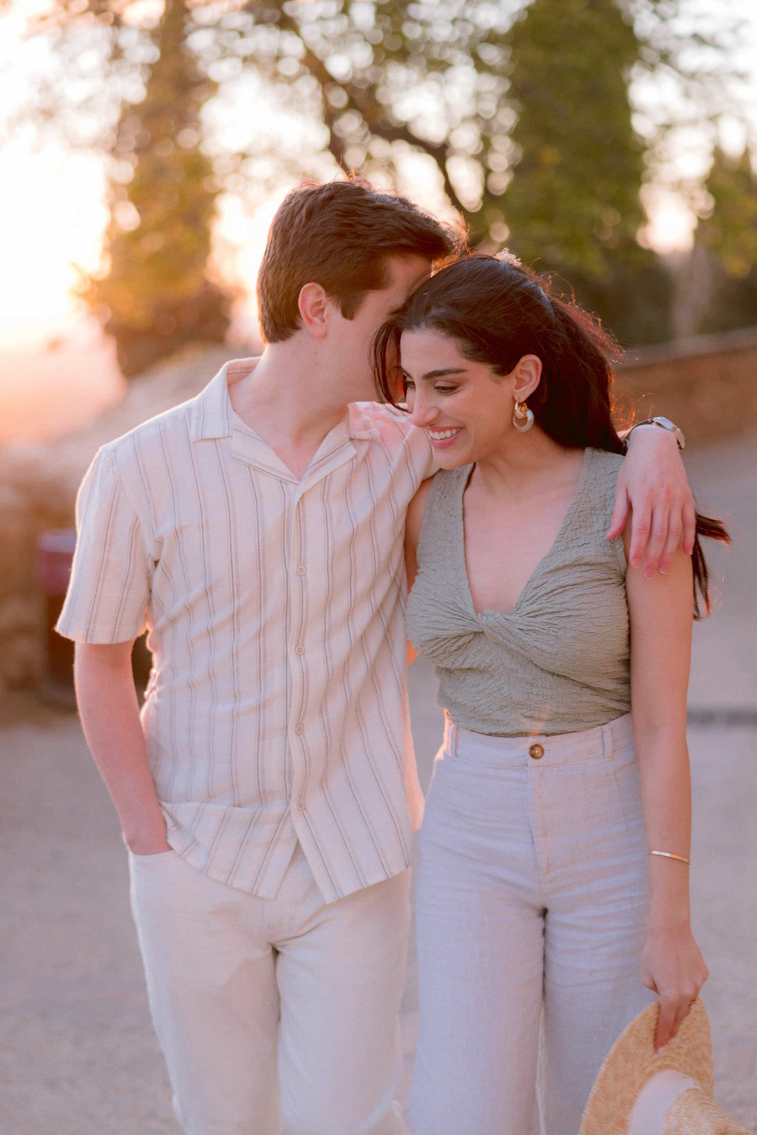 A romantic sunset moment captured between a couple in casual summer attire.