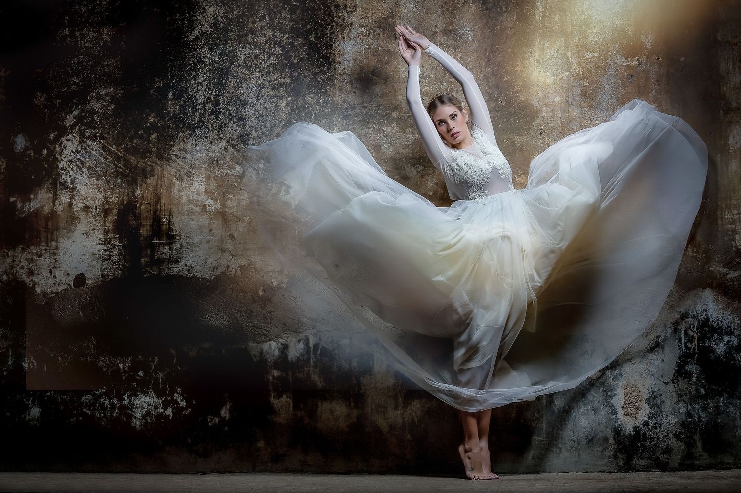 Ethereal dance portrait featuring flowing white dress against textured backdrop.