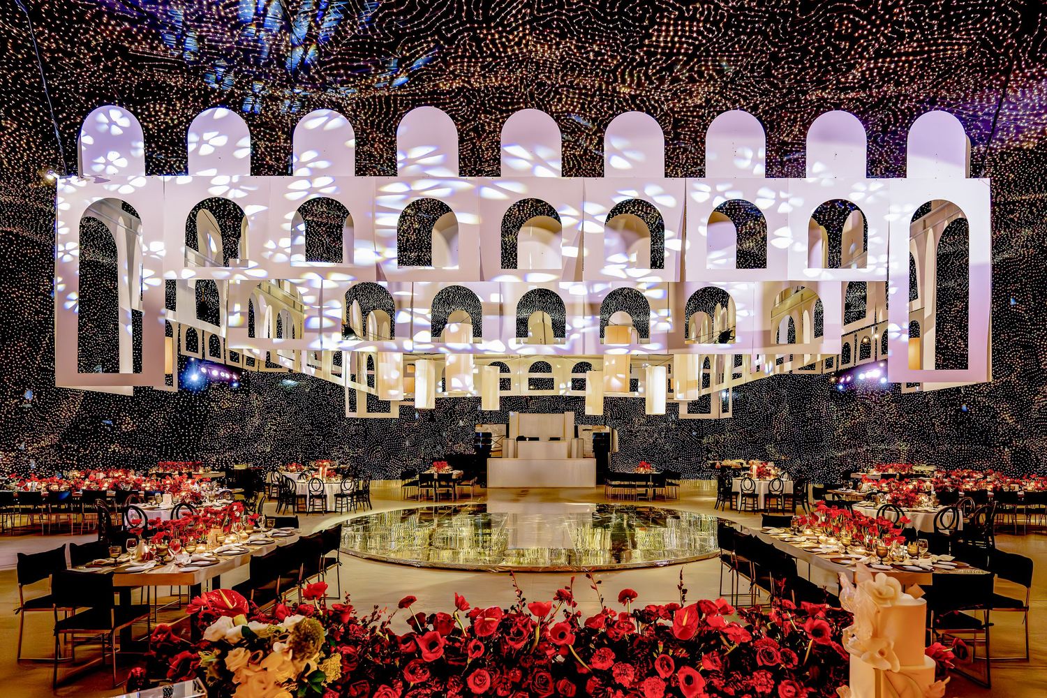 Grand ballroom decorated with twinkling lights and elegant arched architecture.