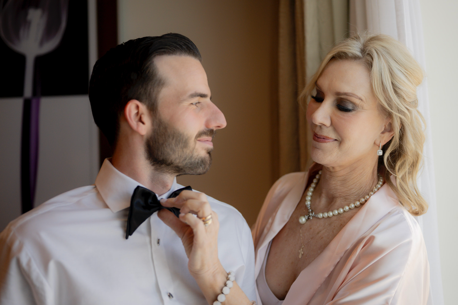 A romantic wedding couple shares intimate moments in a series of elegant indoor portrait photographs.