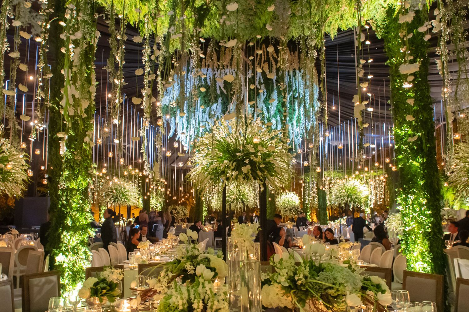 Enchanted forest-themed event space with hanging greenery and ambient lighting creating a magical atmosphere.