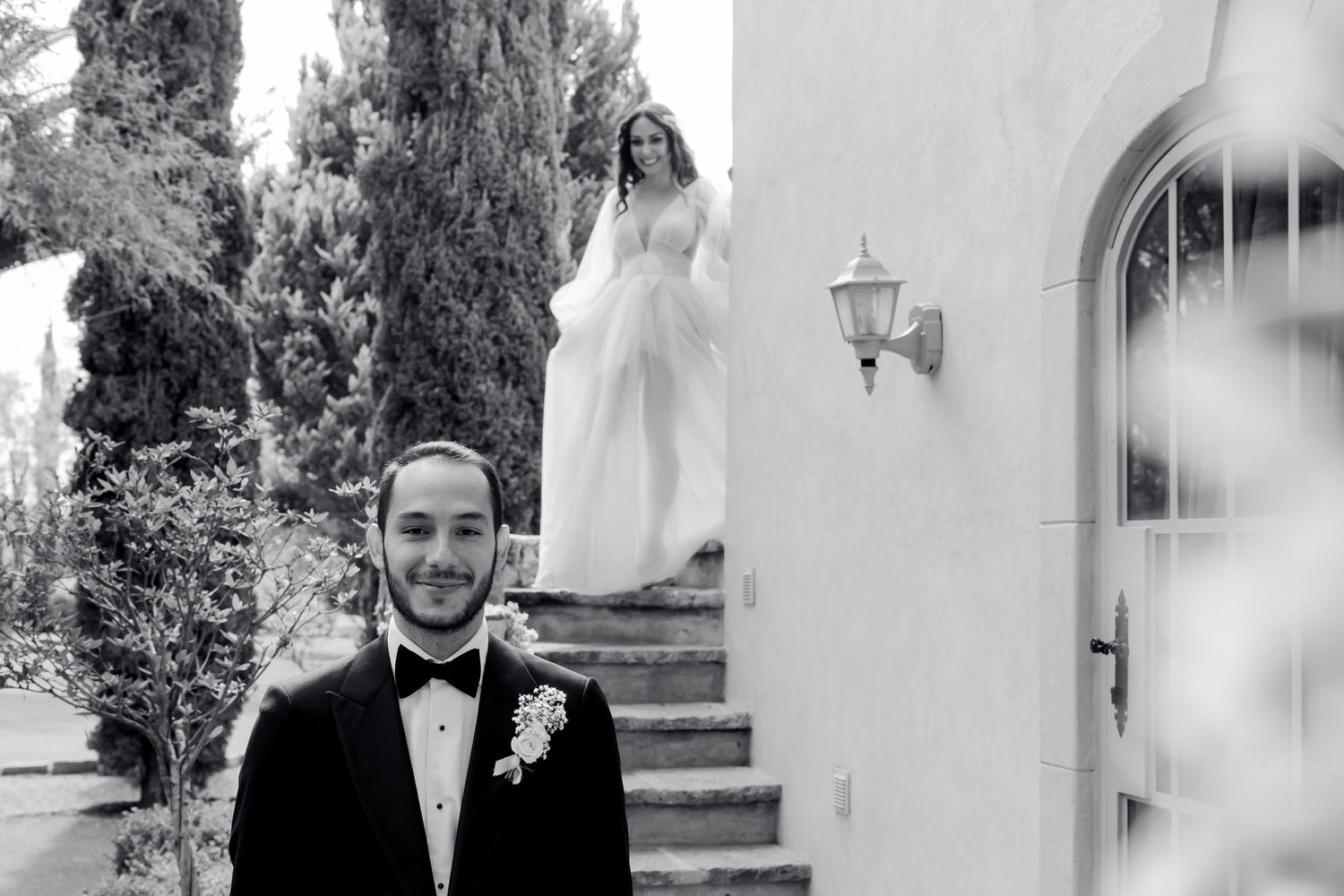 A romantic wedding moment captured in black and white with a couple standing together outdoors.