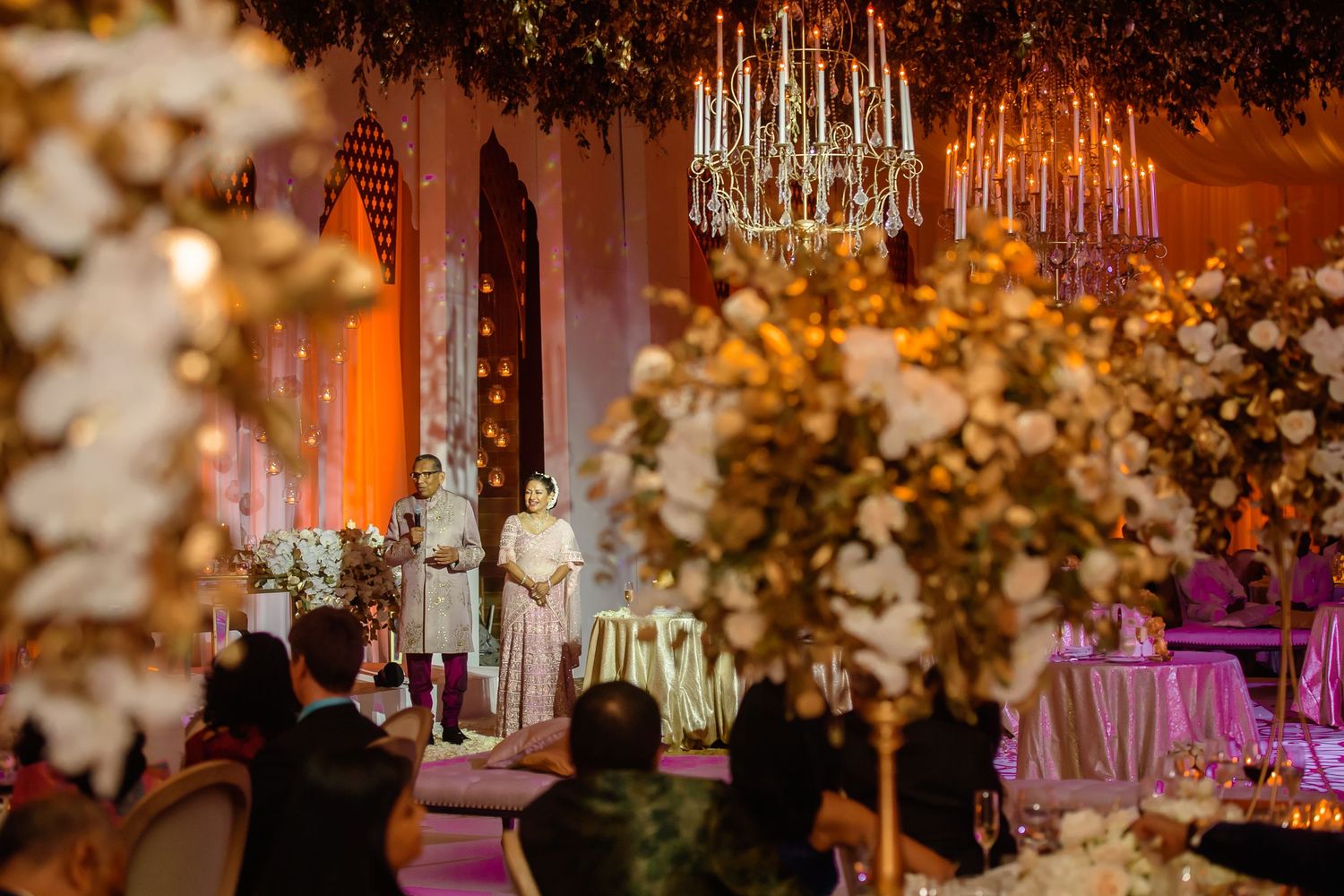 Elegant wedding ceremony venue with crystal chandeliers and floral arrangements creating a romantic atmosphere.