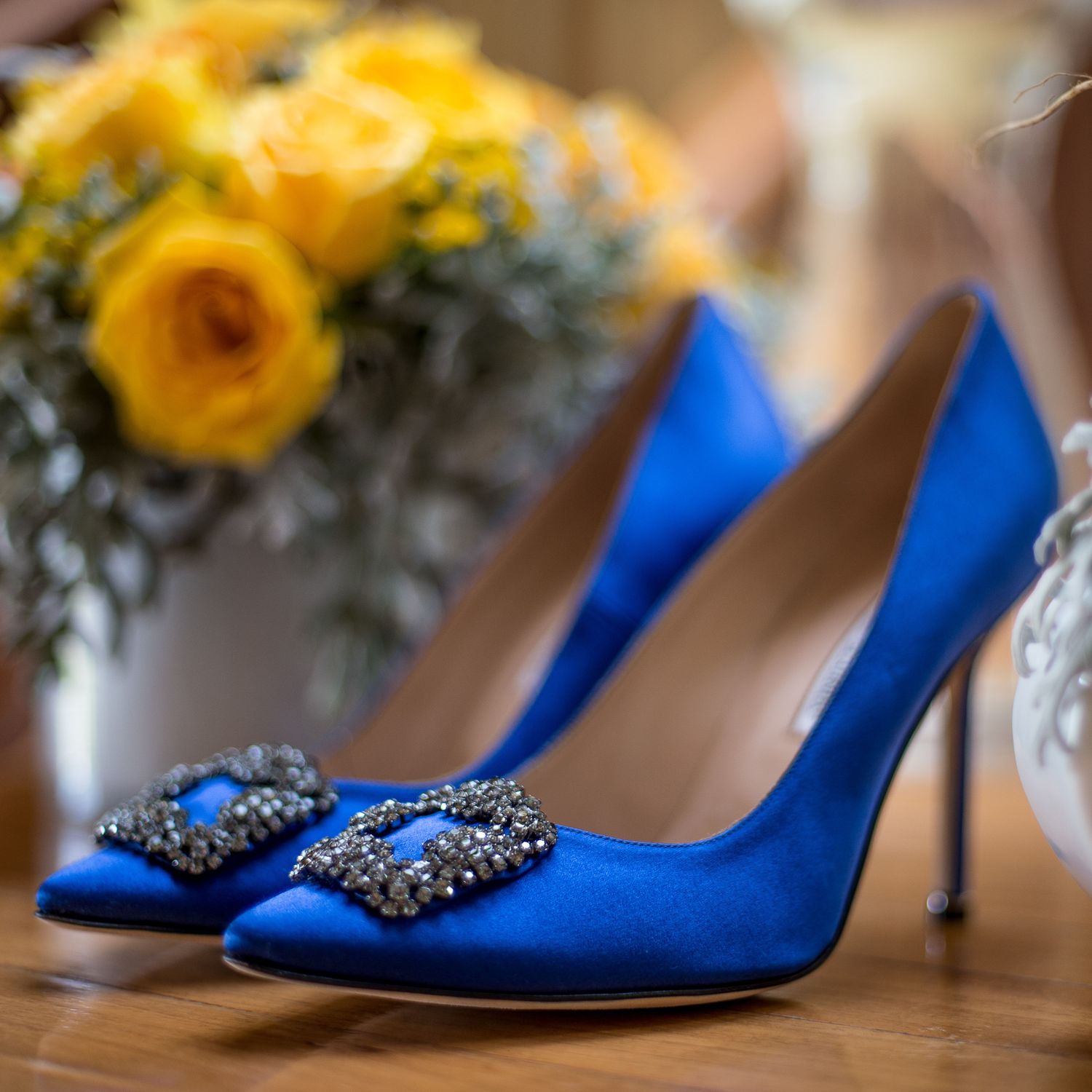 Royal blue embellished wedding shoes displayed with yellow sunflowers.