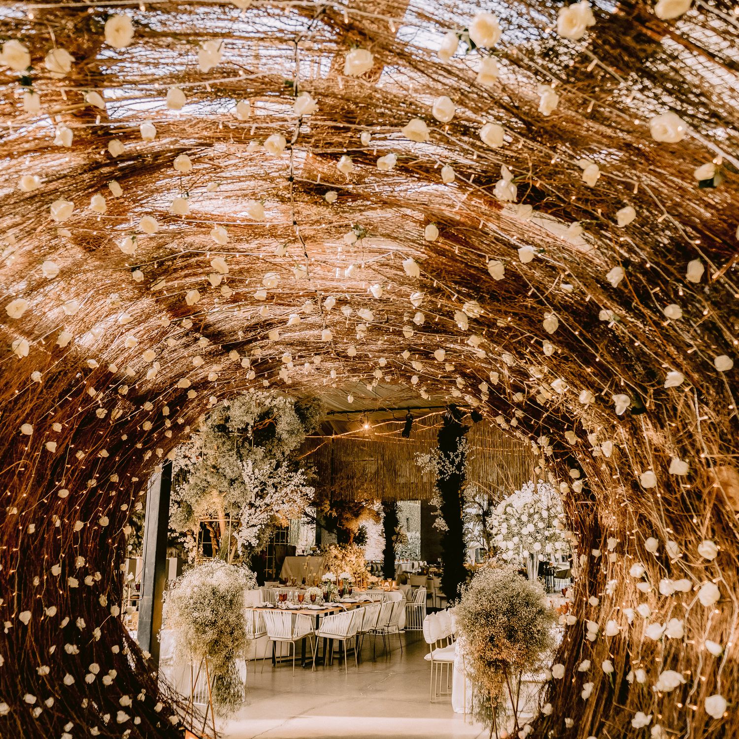 Romantic wedding venue tunnel decorated with twinkling fairy lights and floral arrangements creating a magical ambiance.