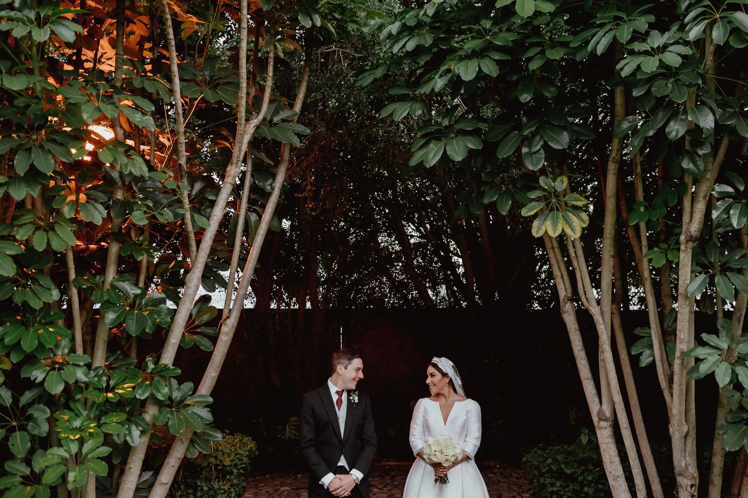 A romantic outdoor wedding ceremony setup surrounded by lush greenery and trees.