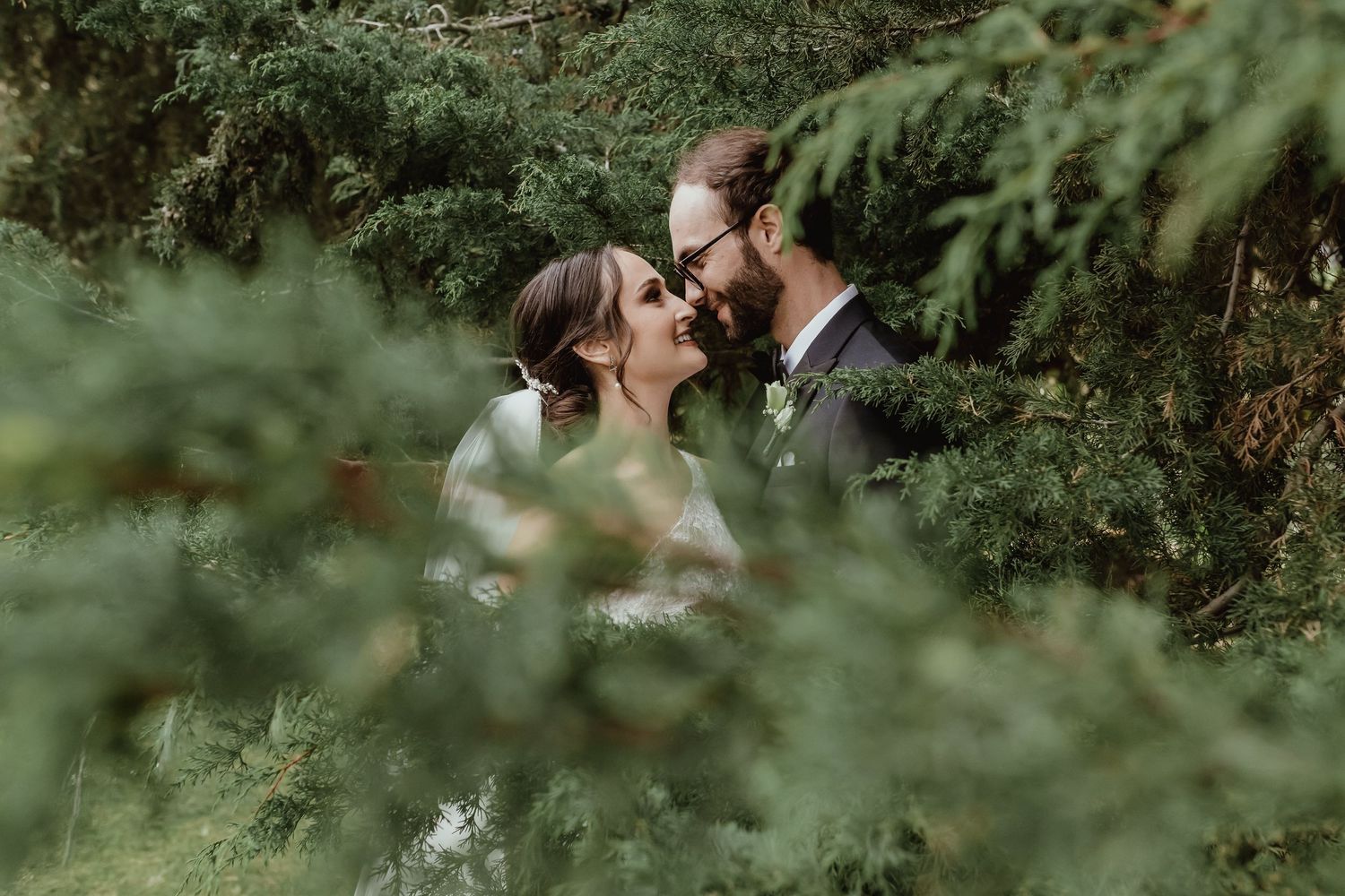 Romantic outdoor wedding ceremony surrounded by lush greenery and natural light.
