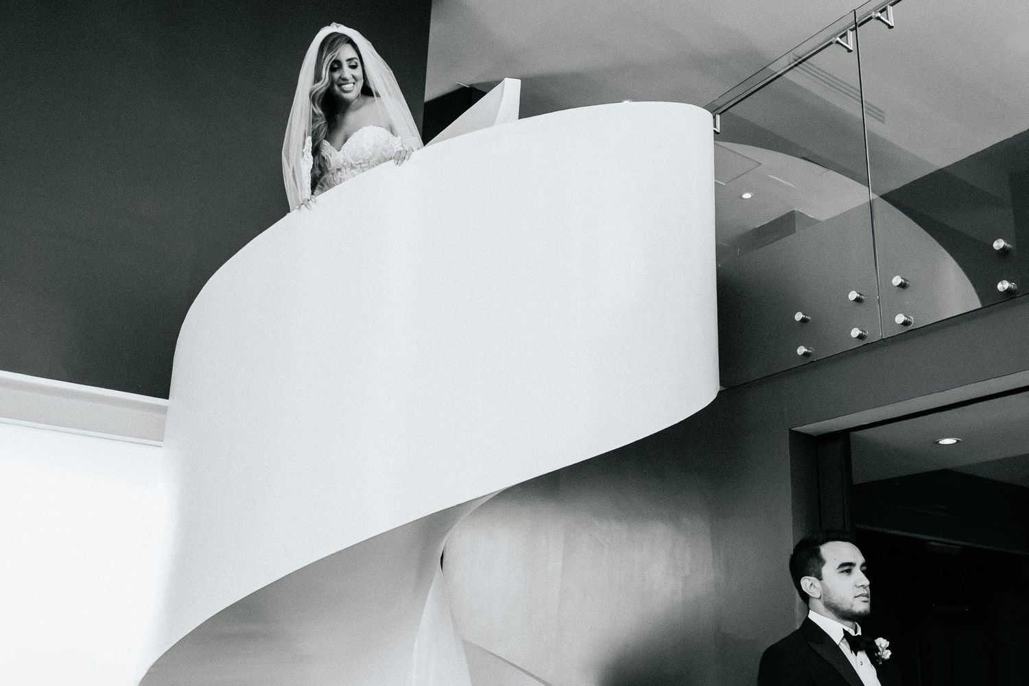 Modern architectural wedding venue featuring sweeping white curved walls and dramatic lighting.
