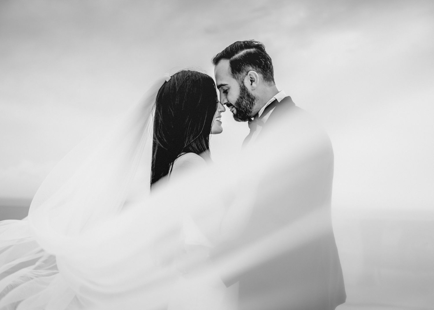 Artistic black and white wedding portraits with soft focus and dramatic lighting.