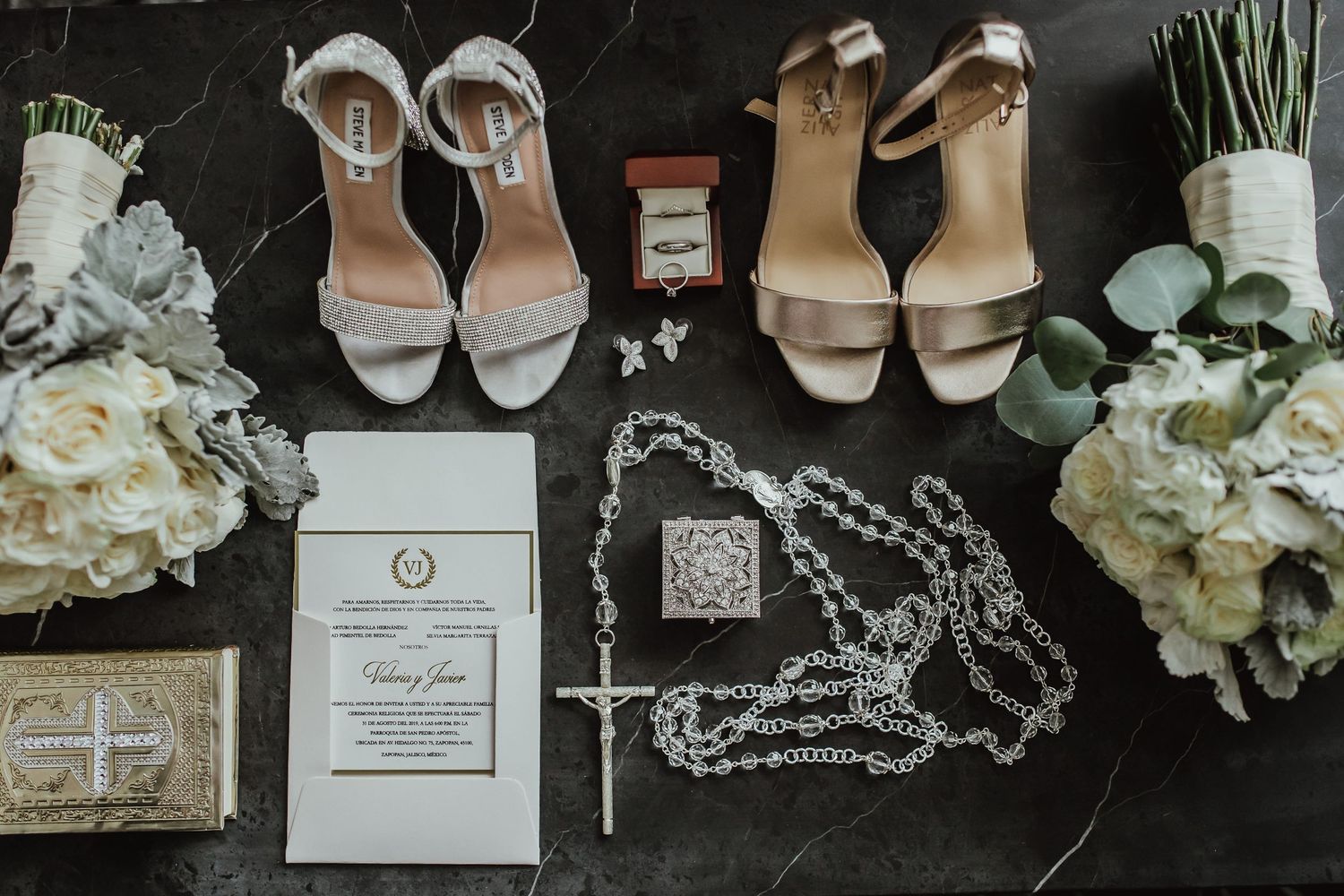 Wedding accessories flatlay including jewelry, flowers, shoes and invitation suite.