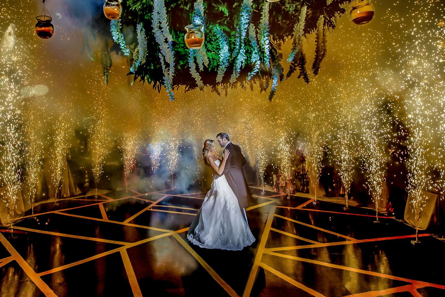 Elegant wedding venue decorated with cascading floral arrangements and dramatic lighting.
