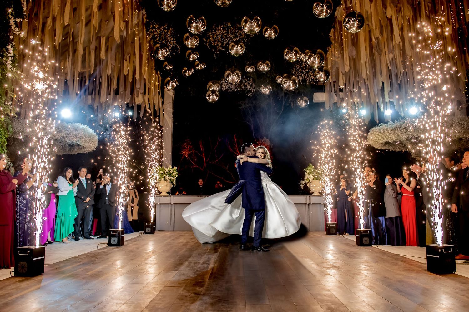 Wedding reception venue decorated with cascading lights and dramatic pyrotechnic effects.