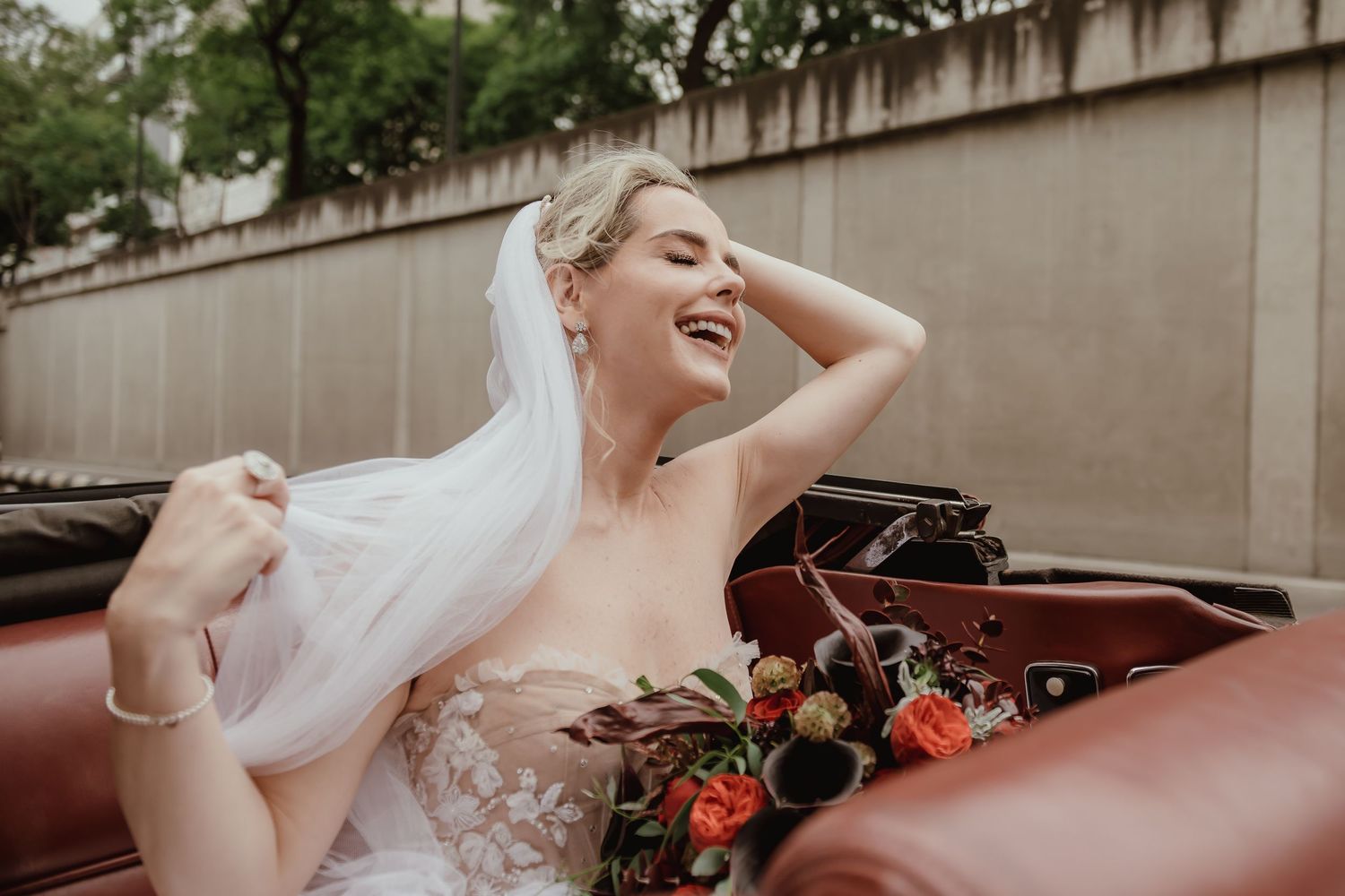 Joyful wedding moments captured with vintage car and floral decorations.