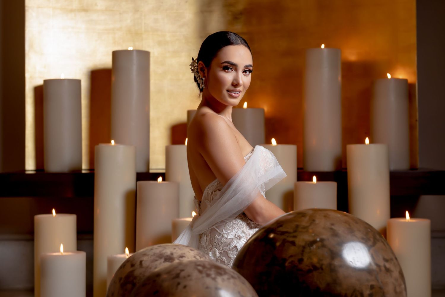 Elegant bridal portrait with white pillar candles creating romantic ambient lighting.
