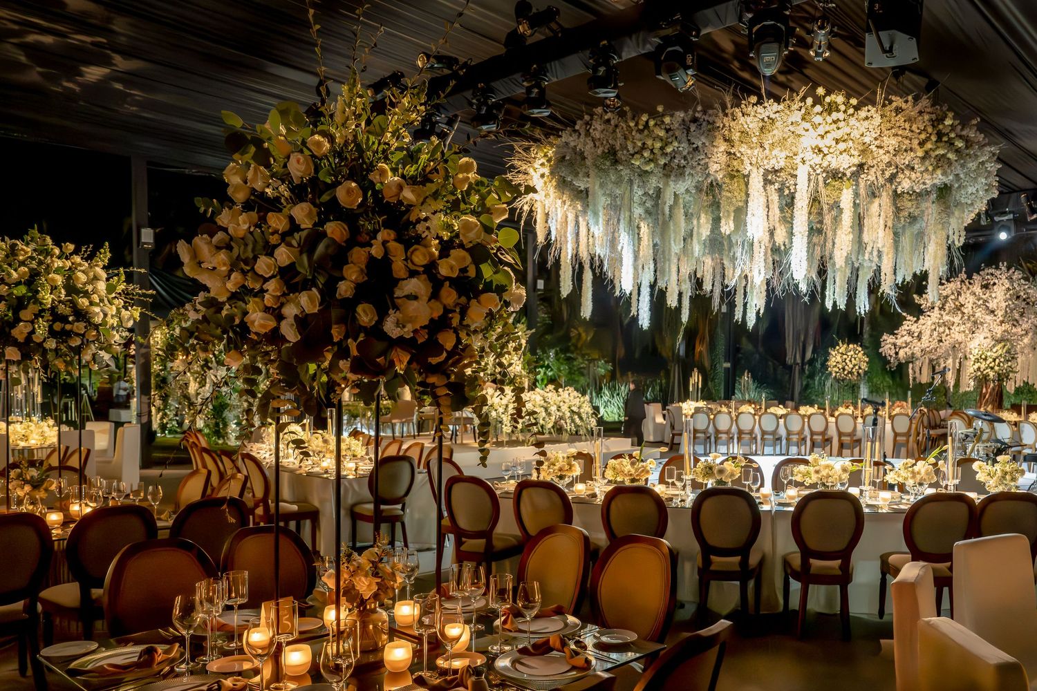 Luxurious wedding reception venue with hanging crystals and enchanted forest theme.