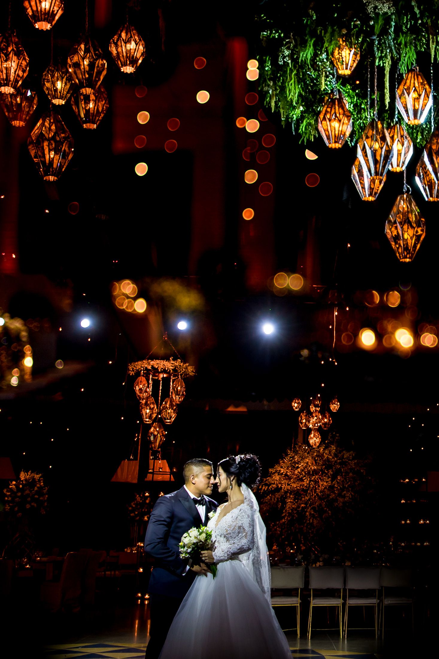 Romantic evening wedding scene with vintage lanterns and twinkling lights creating ambiance.