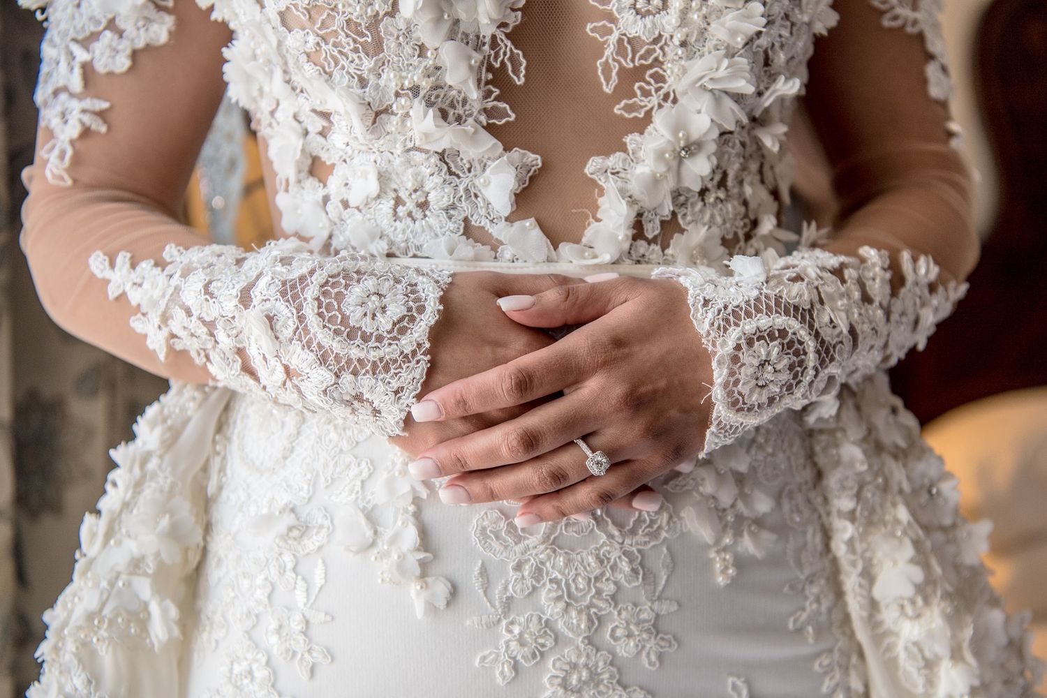 Close-up views of delicate white lace details on a wedding gown.
