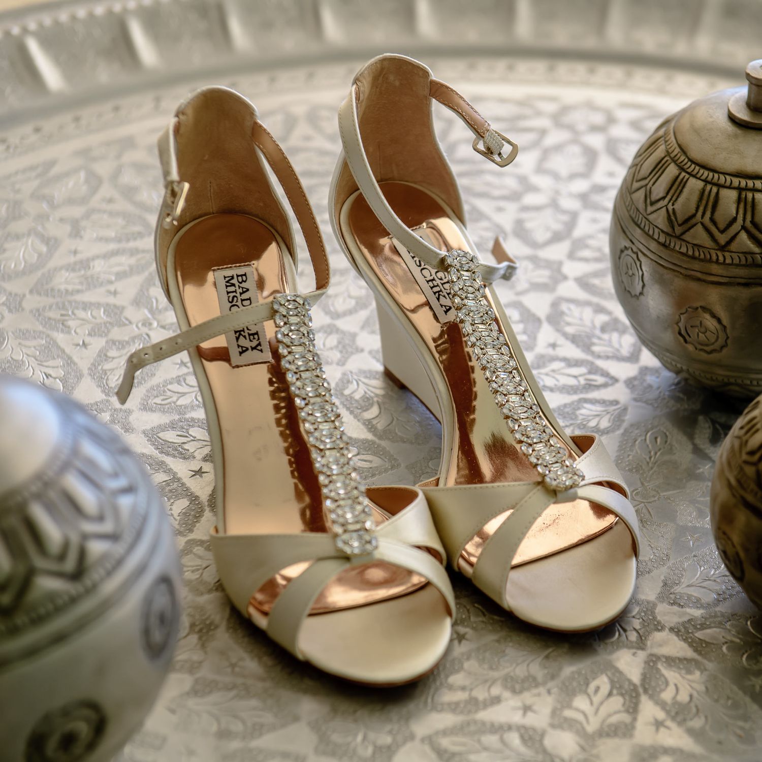 Crystal-embellished bridal sandals displayed on ornate silver tray.