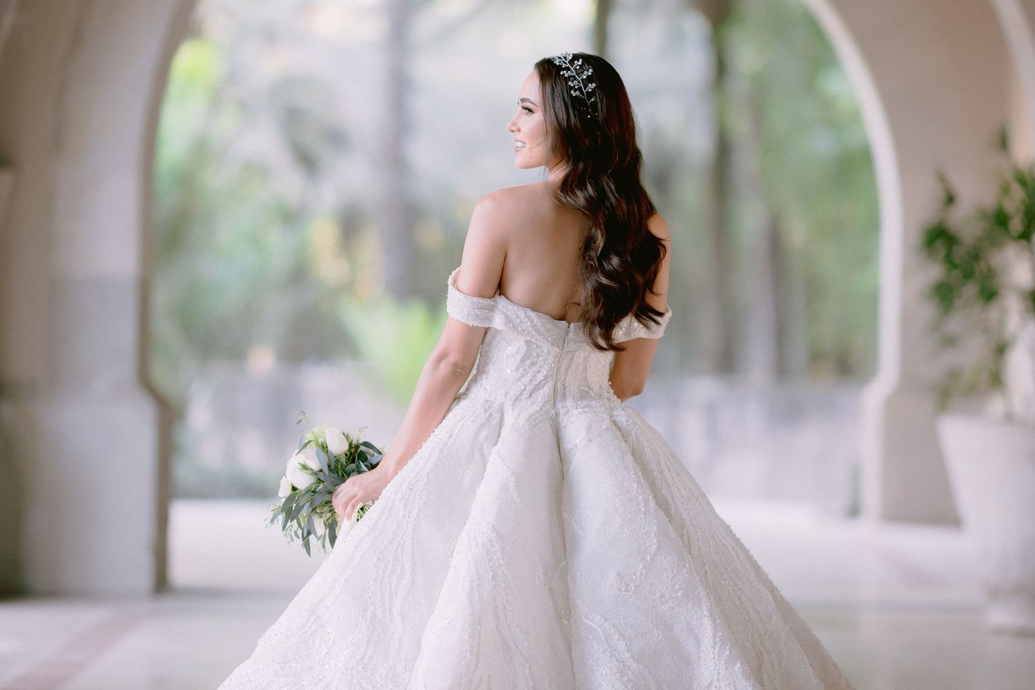 Artistic bridal portrait showcasing the dramatic sweep of a princess ball gown in natural light.