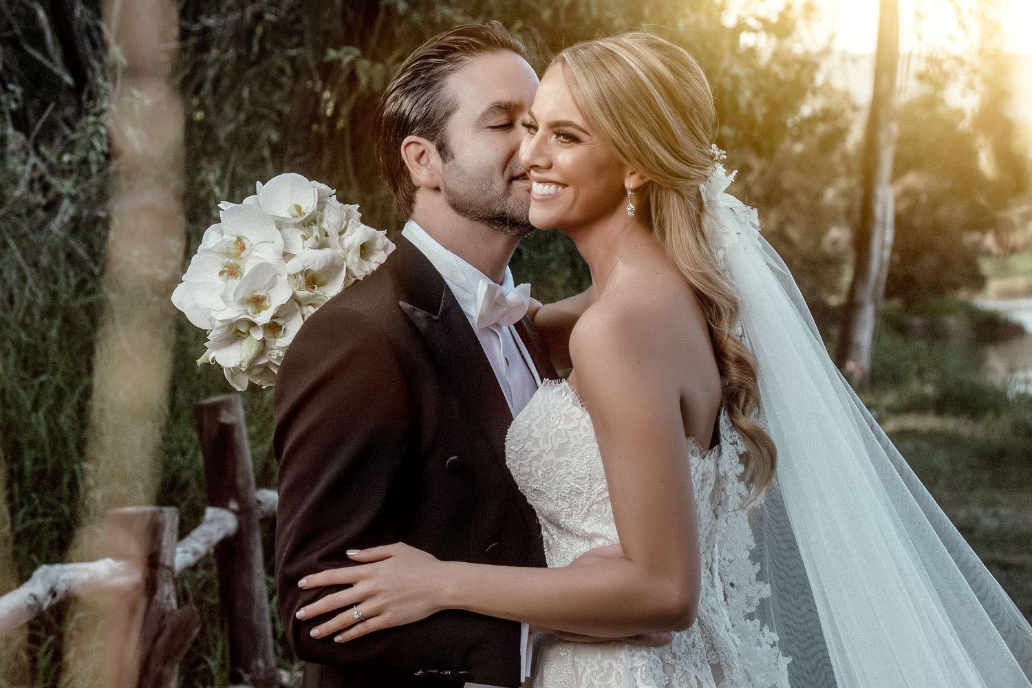 Golden hour wedding portraits with sunlight filtering through trees.