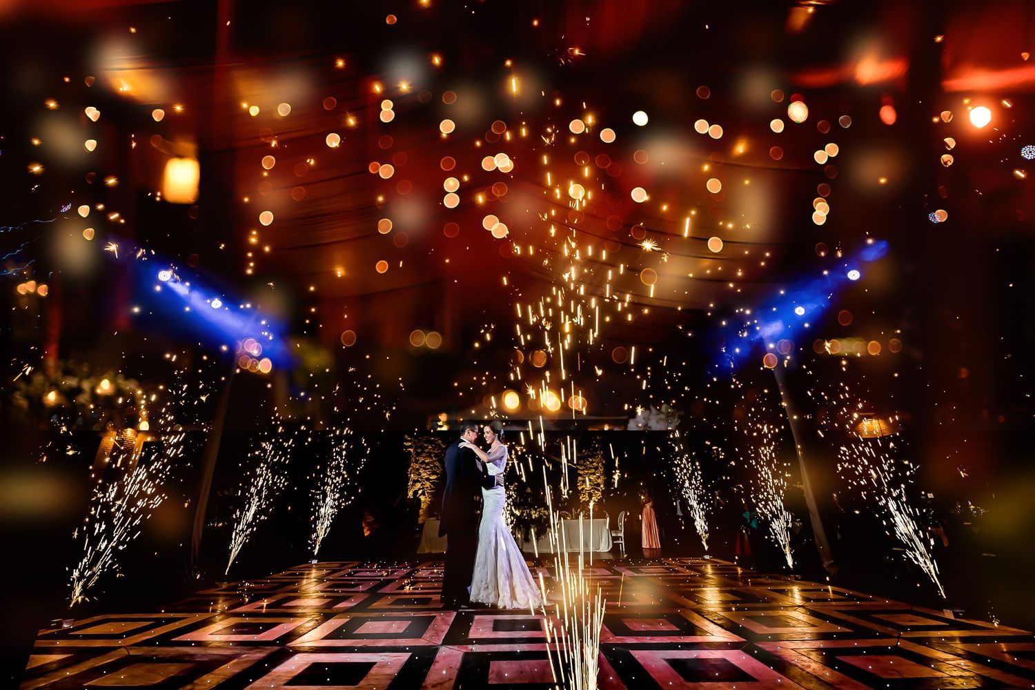 Sparklers create magical light trails during a wedding reception dance floor moment.