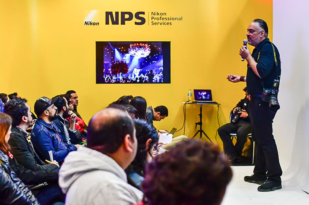 Yellow-walled conference room with presentation screen and seated audience.