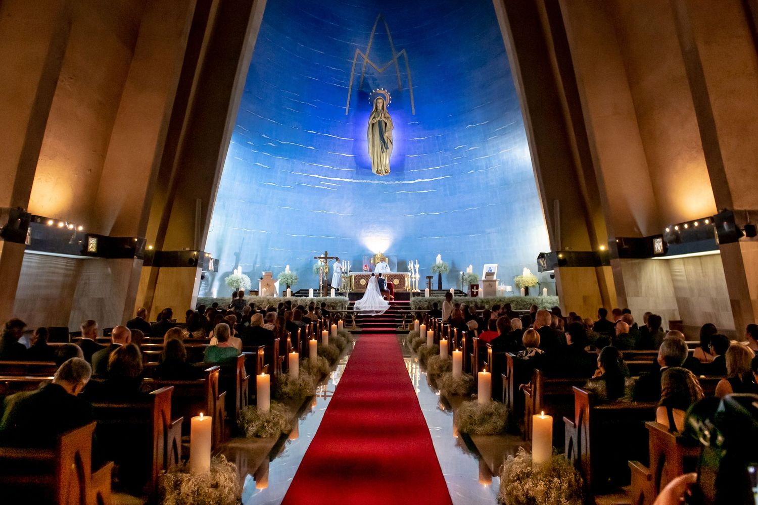 Elegant church wedding ceremony with dramatic lighting and red carpet aisle.