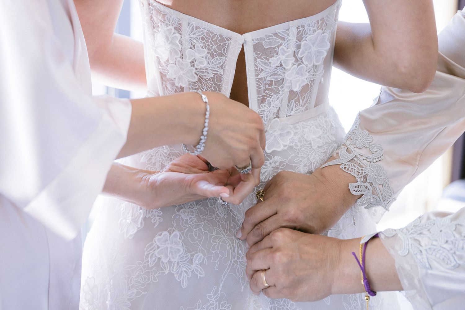 Detail shots of wedding dress adjustments and final preparations.