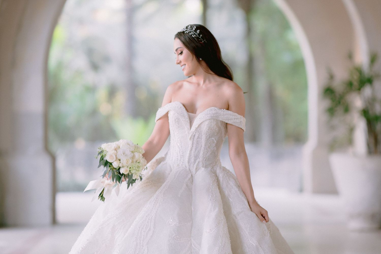 Ethereal wedding photography featuring dramatic ball gown silhouette in outdoor garden setting.